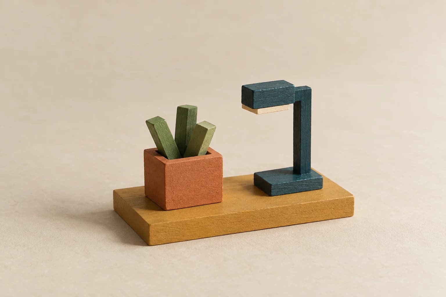 A tiny angular plant and unlit teal desk lamp sit on a warm ochre slab, framed with open space against an ivory background.